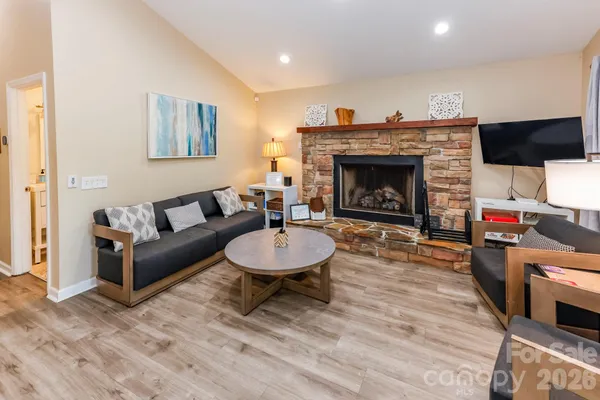 a living room with furniture a fireplace and a flat screen tv