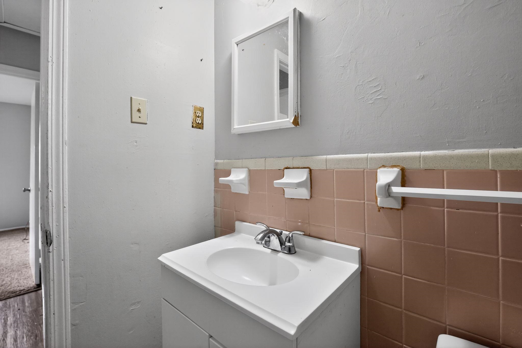 3420 Forrester Road Memphis, TN 38109 - Photo 21 of 30 Half bathroom with vanity, a wainscoted wall, tile walls, and a textured wall