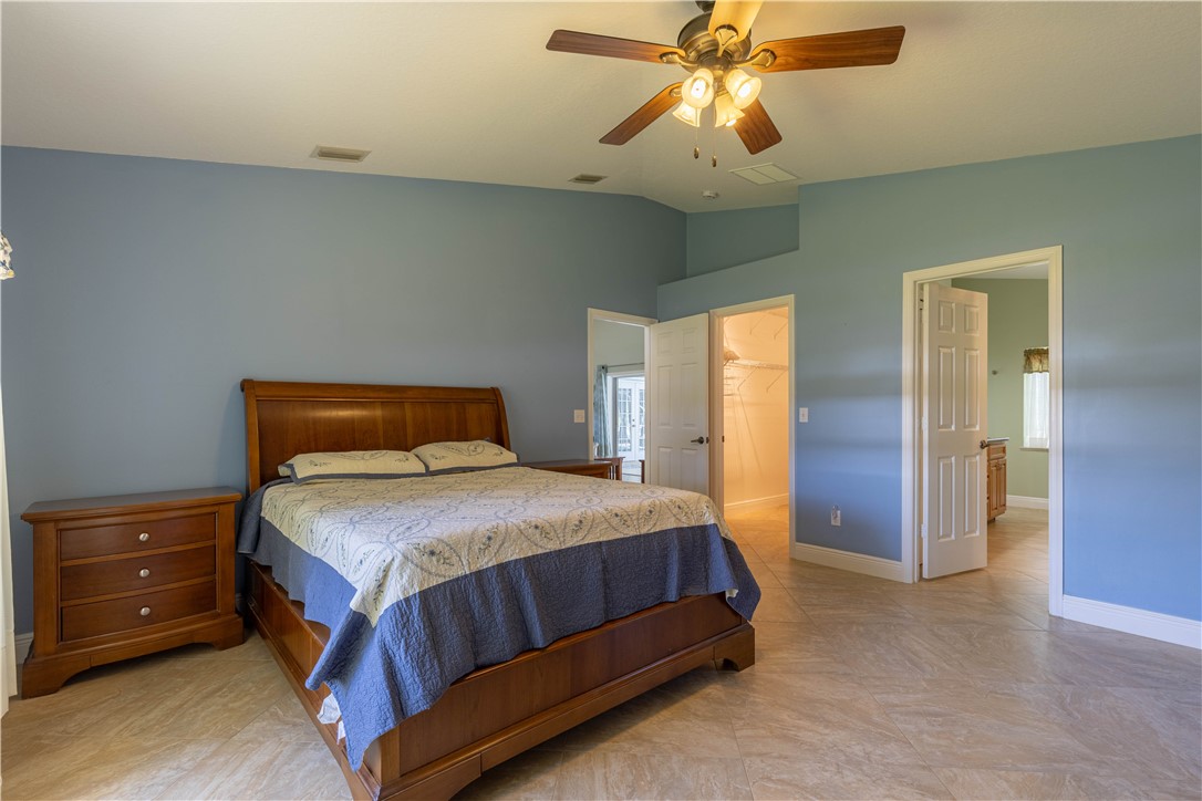 414 Ash Street Sebastian, FL 32958 - Photo 16 of 36 a bedroom with a bed and a chandelier
