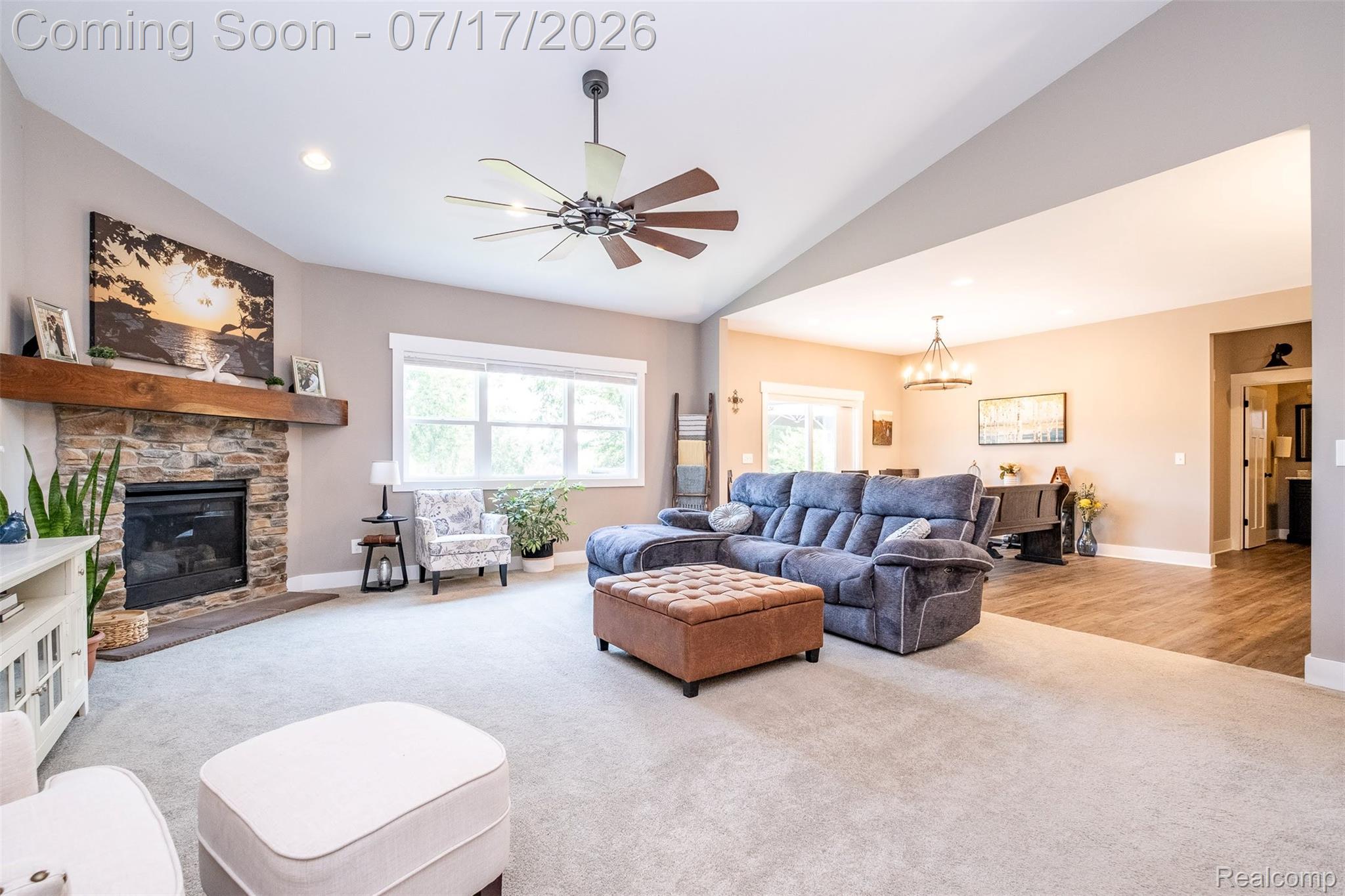 12349 Sugar Maple Drive Fenton, MI 48430 - Photo 7 of 67 Open concept living space featuring a stone fireplace with wood mantel, vaulted ceiling, and a large window