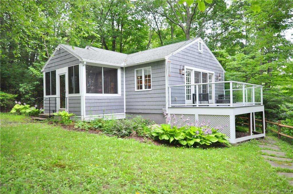 23 Floren Pond Road Litchfield, CT 06759 - Photo 1 of 1 a view of a house with brick walls and a yard with plants and large trees