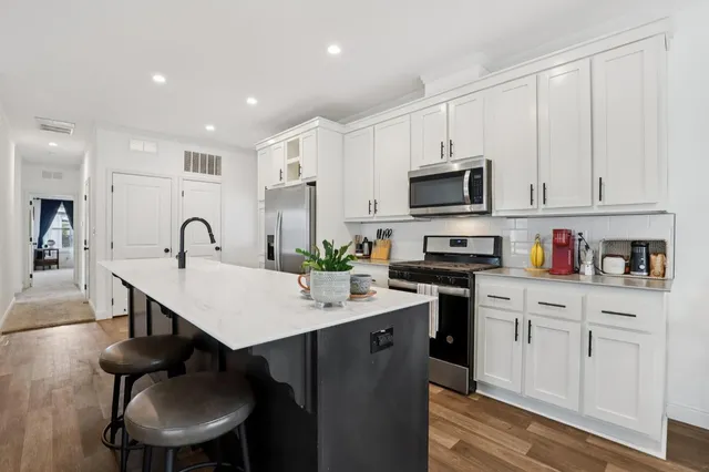 a kitchen with a sink stainless steel appliances and white cabinets