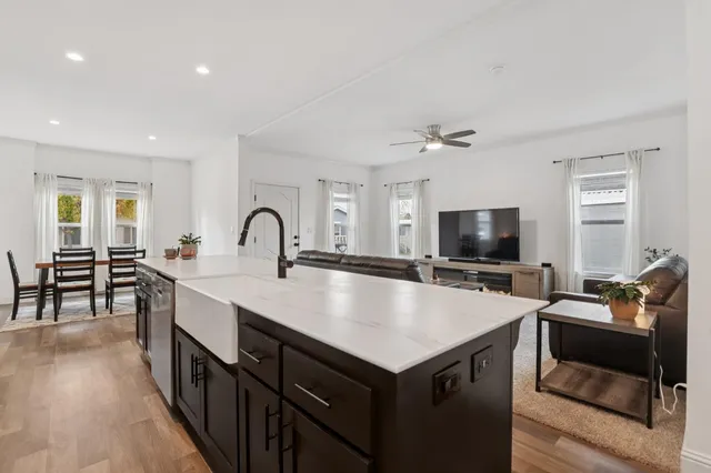 a large kitchen with sink a counter top space and stainless steel appliances