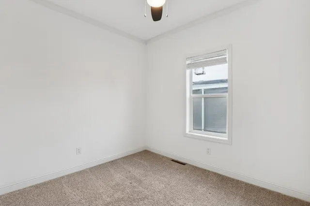 an empty room with windows and cabinet
