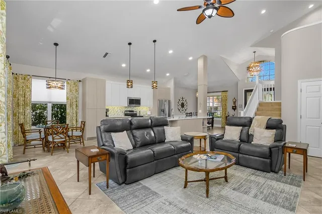 a living room with furniture kitchen view and a wooden floor
