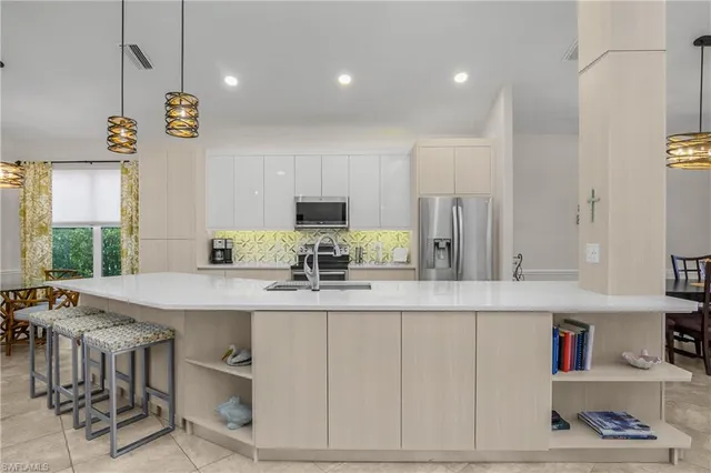 a kitchen with kitchen island granite countertop a sink cabinets and window