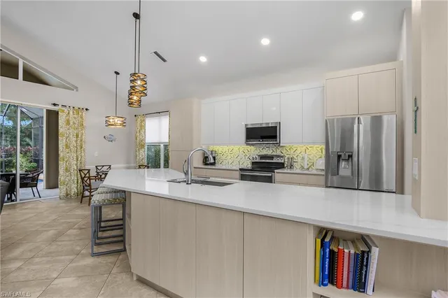 a large kitchen with kitchen island a large counter top stainless steel appliances and cabinets