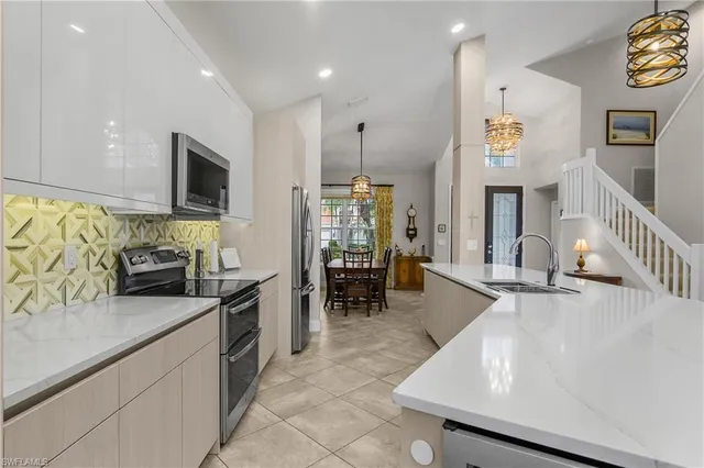 a kitchen with stainless steel appliances granite countertop sink stove top oven and cabinets