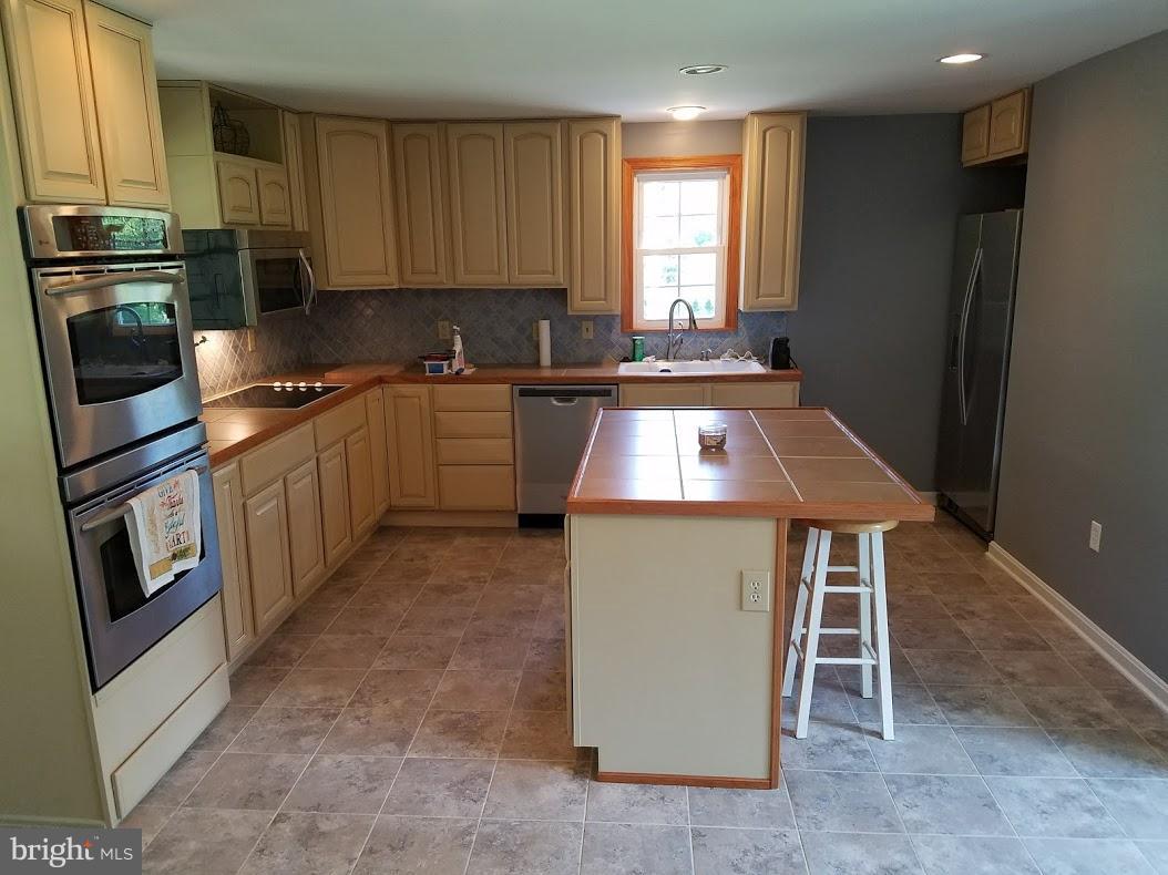 13612 Coppermine Road Union Bridge, MD 21791 - Photo 8 of 15 a kitchen with refrigerator a stove a sink and a microwave