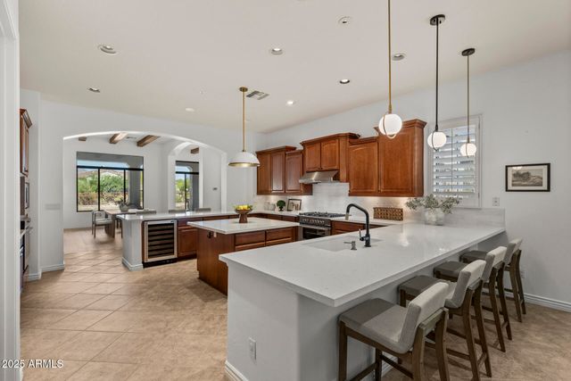 a kitchen with a stove a sink a counter top space and living room view
