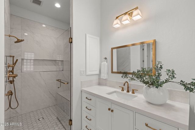 a bathroom with a sink a potted plant and a mirror