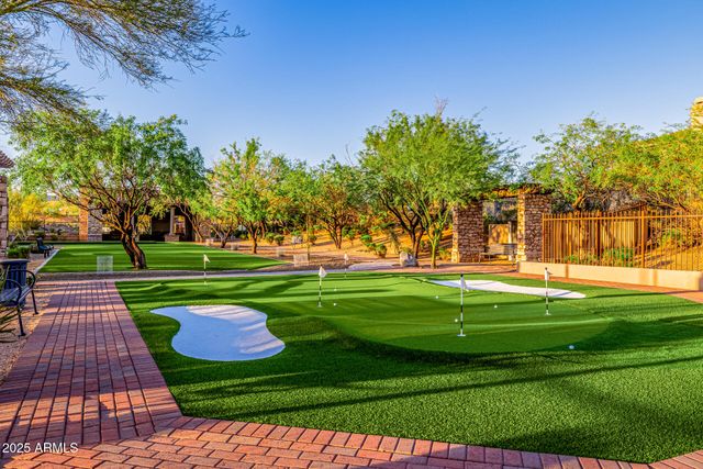 a view of a white house with a fountain and a tree