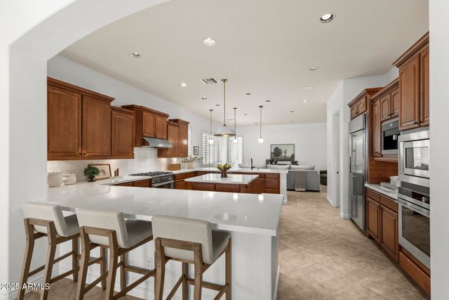 a kitchen with sink a stove and chairs