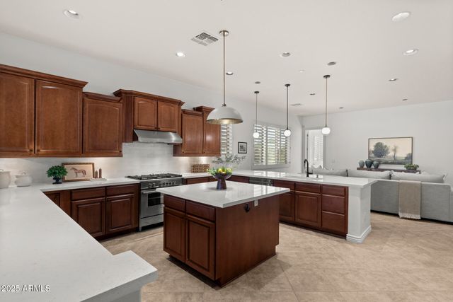 a kitchen with stainless steel appliances granite countertop a sink a stove and a refrigerator