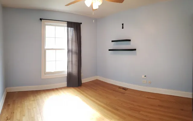 an empty room with a window and wooden floor