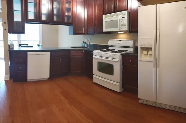 a kitchen with granite countertop wooden cabinets and stainless steel appliances