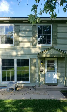 a front view of a building with a garden and plants