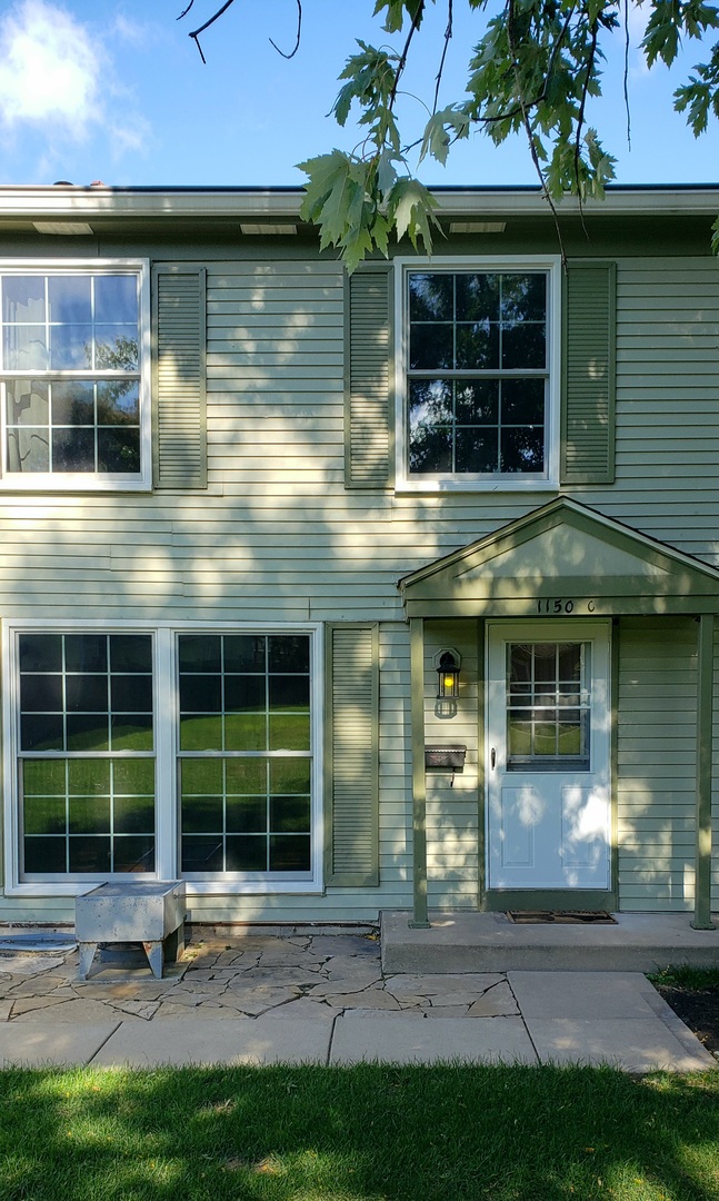 1150 Mt Vernon Court, Unit C Wheaton, IL 60189 - Photo 2 of 21 a front view of a building with a garden and plants