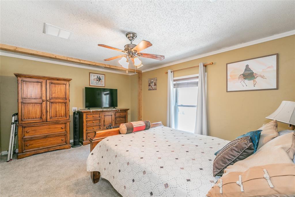 1055 Miller Road Azle, TX 76020 - Photo 14 of 40 Bedroom with light colored carpet, ornamental molding, a textured ceiling, and a ceiling fan