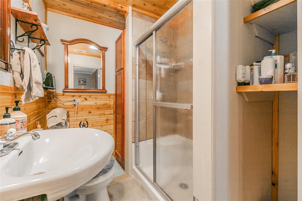 1055 Miller Road Azle, TX 76020 - Photo 19 of 40 Primary bath with a sink, a stall shower, wooden walls, and wood ceiling