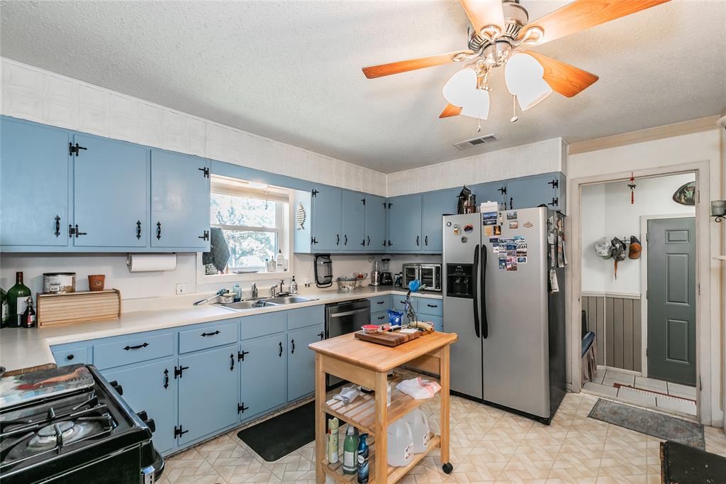 1055 Miller Road Azle, TX 76020 - Photo 9 of 40 Kitchen featuring stainless steel appliances, blue cabinets, a sink, light countertops, and light floors