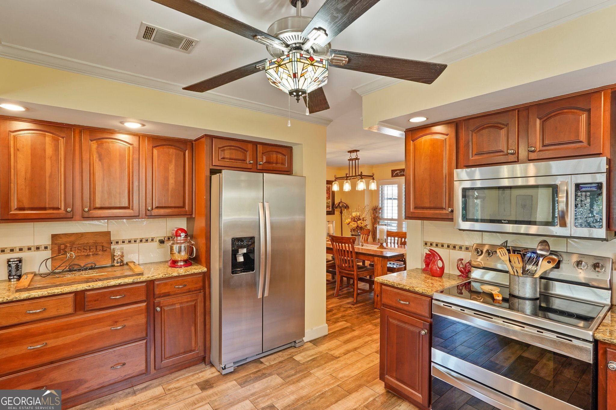 600 Shore Edge Trc St. Simons Island, GA 31522 - Photo 38 of 93 a kitchen with stainless steel appliances granite countertop a refrigerator a stove and a sink with cabinets