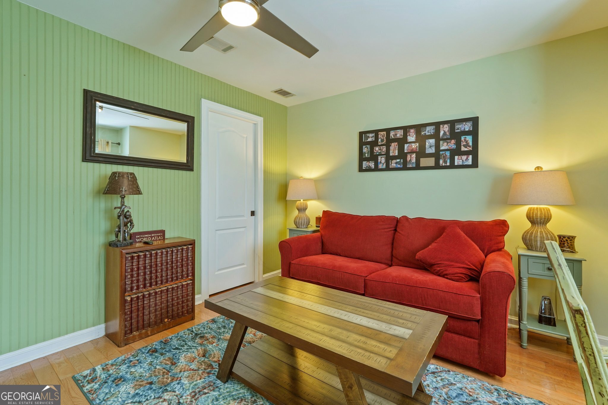 600 Shore Edge Trc St. Simons Island, GA 31522 - Photo 66 of 93 a blue couch sitting in a living room next to a lamp