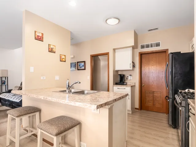 a kitchen with kitchen island a counter top space a sink stainless steel appliances and cabinets