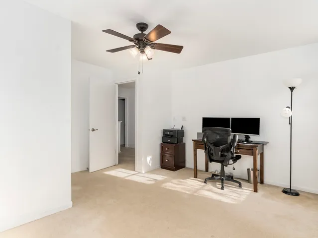 a view of a workspace with furniture and a window