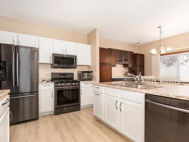 a kitchen with a sink stainless steel appliances and cabinets