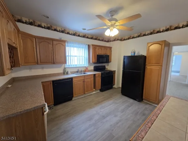 a kitchen with cabinets a sink a window and stainless steel appliances
