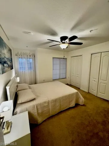 a bed room with a bed and a ceiling fan