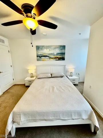 a bedroom with a bed ceiling fan and a dresser