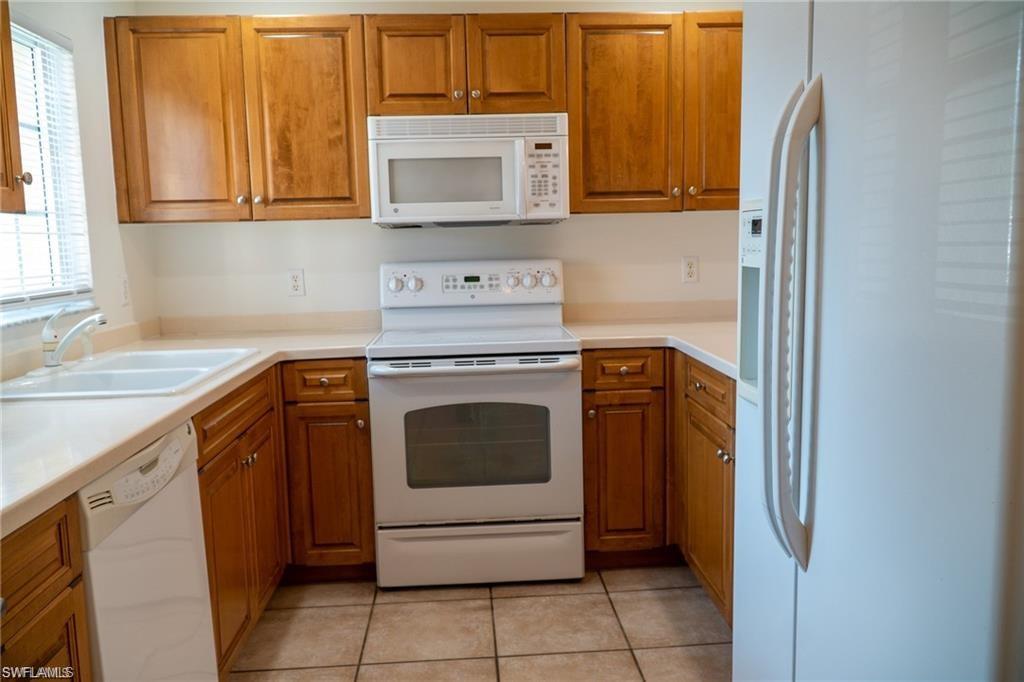 9430 Ivy Brook Run, Unit 403 Fort Myers, FL 33913 - Photo 6 of 25 a kitchen with a stove top oven and sink