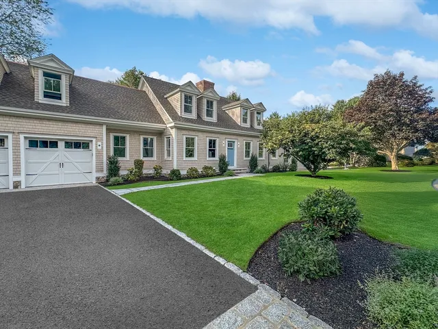 a front view of a house with a garden and trees