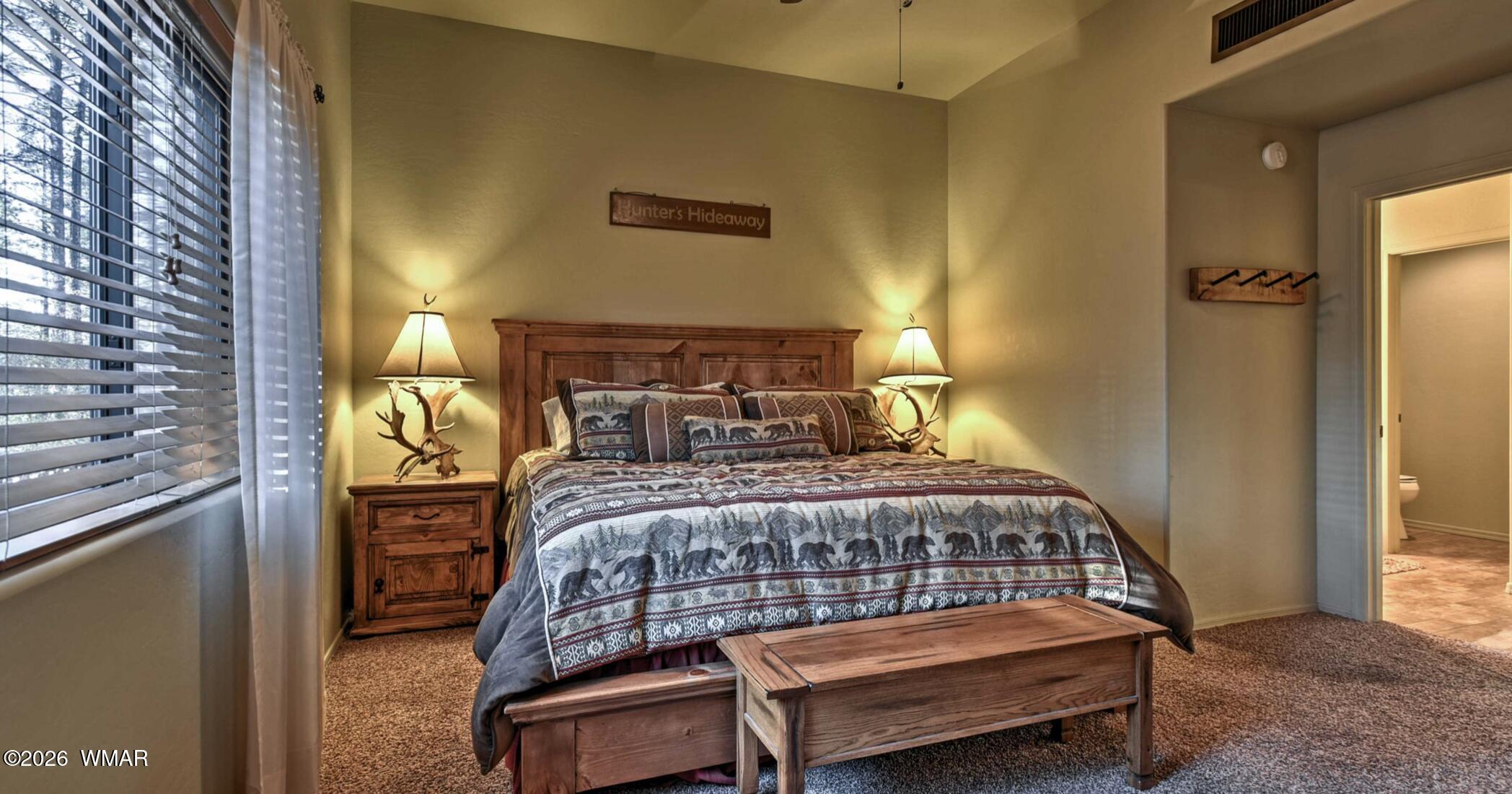 2942 Timber Line Road Pinetop, AZ 85935 - Photo 13 of 27 a bedroom with a bed a lamp and a window