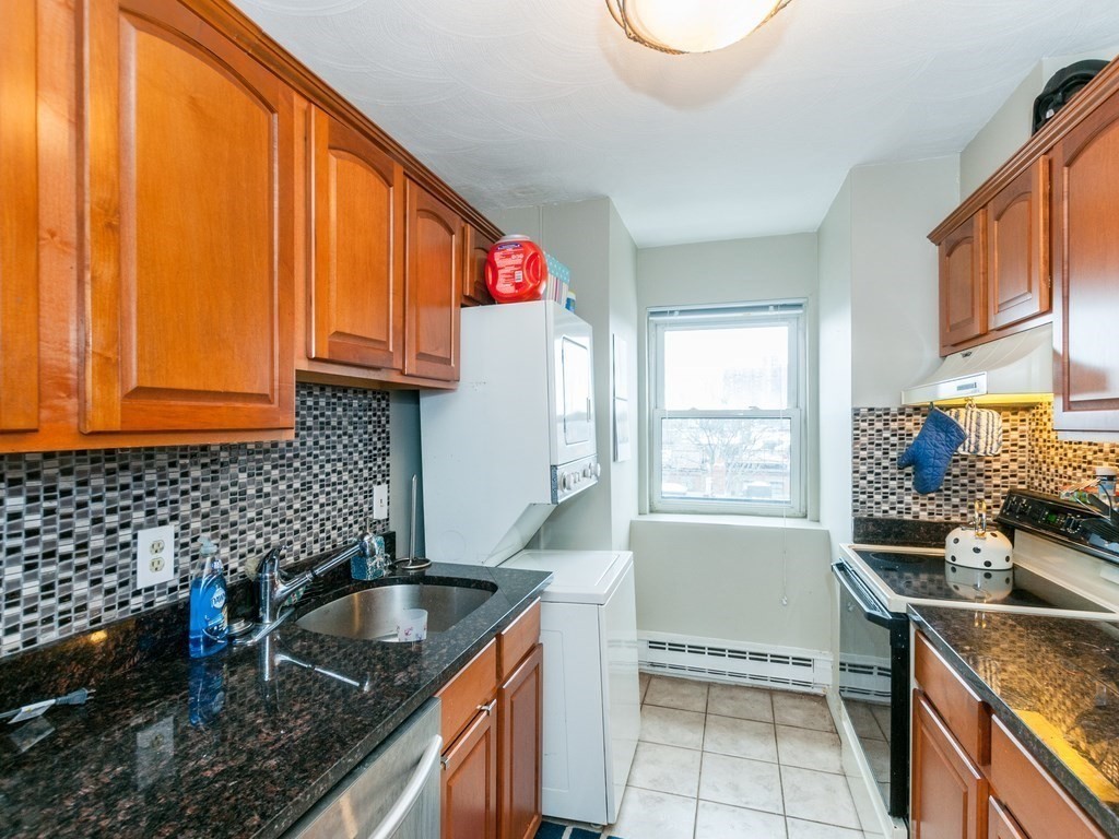 532 Tremont Street, Unit 4 Boston, MA 02118 - Photo 6 of 13 a kitchen with granite countertop a sink a stove and cabinets