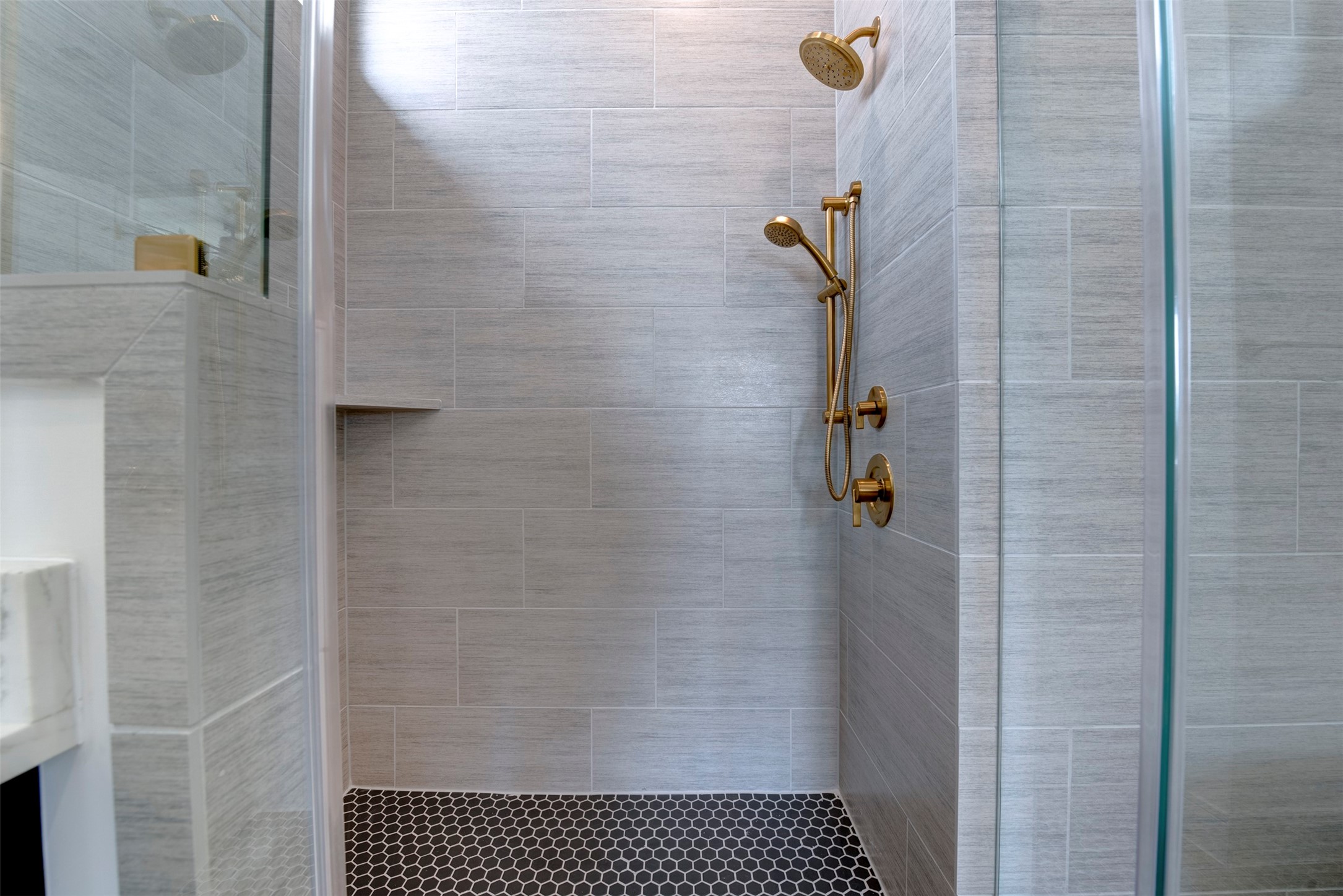 7120 Gary Street, Unit B Houston, TX 77055 - Photo 23 of 29
This photo showcases a modern bathroom featuring a spacious walk-in shower with elegant marble tiles and a stylish gold shower fixture. The space is complemented by a sleek vanity with a marble countertop and contemporary lighting.