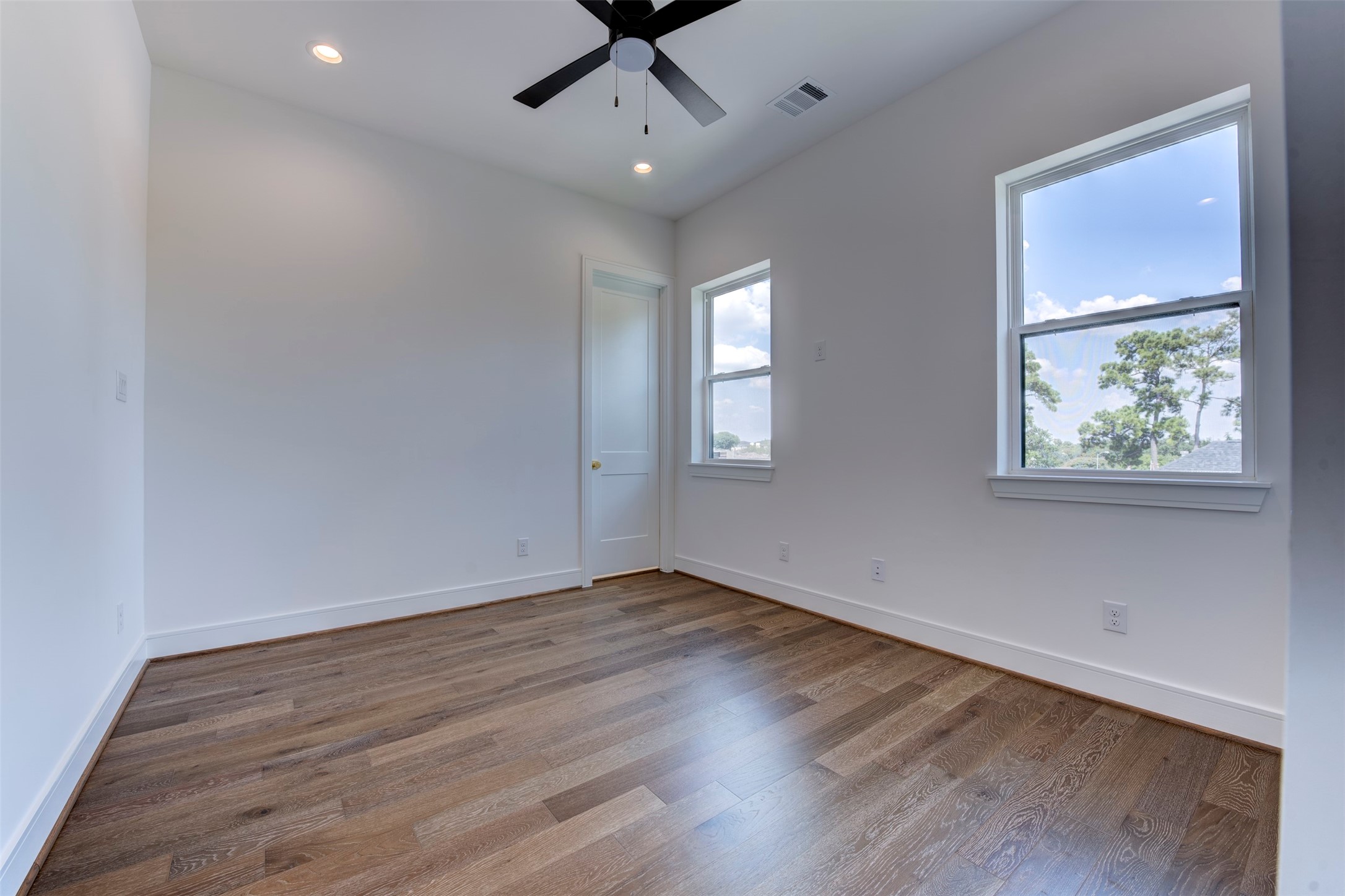 7120 Gary Street, Unit B Houston, TX 77055 - Photo 25 of 29 Secondary bedroom on the third level, complete with a modern ceiling fan, hardwood floors, an en-suite bathroom, and a closet.
