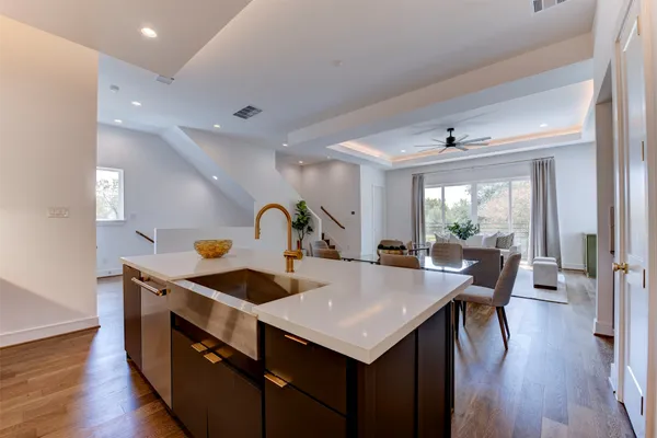 a living room with stainless steel appliances furniture a rug and a large window