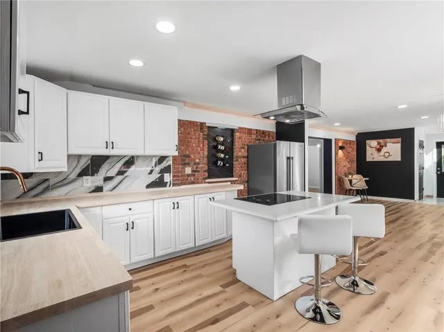 a kitchen with stainless steel appliances kitchen island granite countertop a sink and cabinets