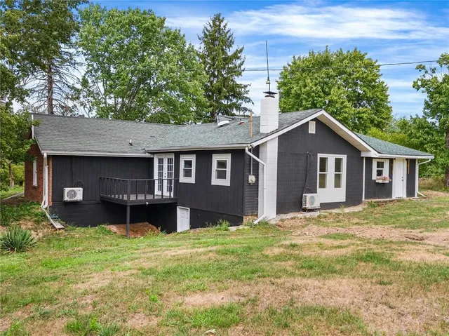 a front view of a house with a yard and trees