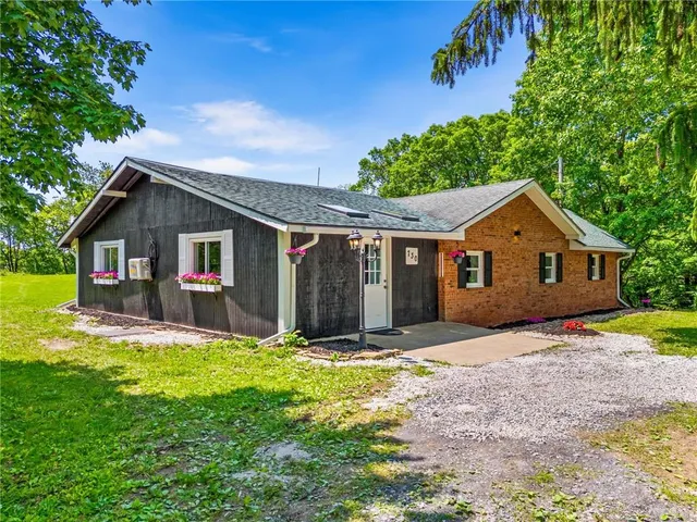 a view of a yard in front of a house with large tree