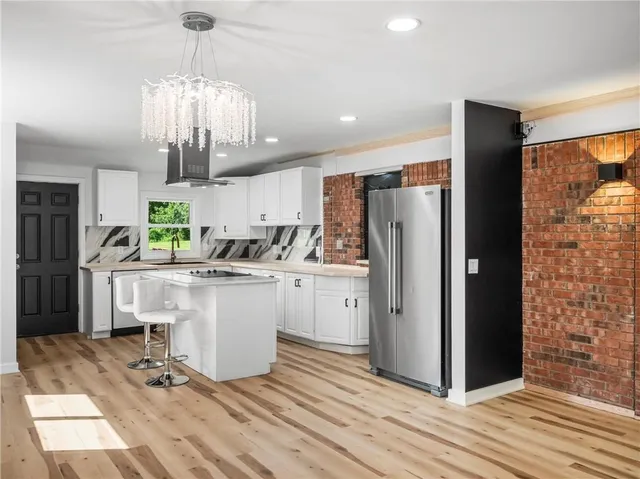 a kitchen with a refrigerator and countertop cabinets