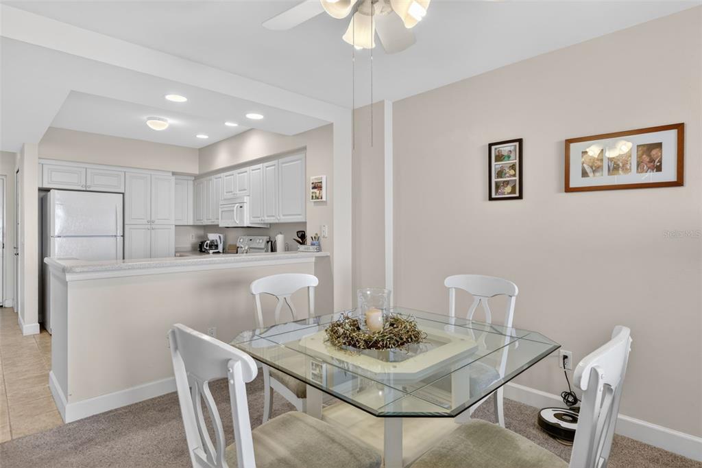 3191 Matecumbe Key Road, Unit 304 Punta Gorda, FL 33955 - Photo 13 of 31 a kitchen with stainless steel appliances kitchen island granite countertop a dining table chairs and a refrigerator