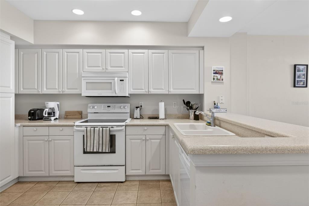 3191 Matecumbe Key Road, Unit 304 Punta Gorda, FL 33955 - Photo 15 of 31 a kitchen with white cabinets appliances and sink