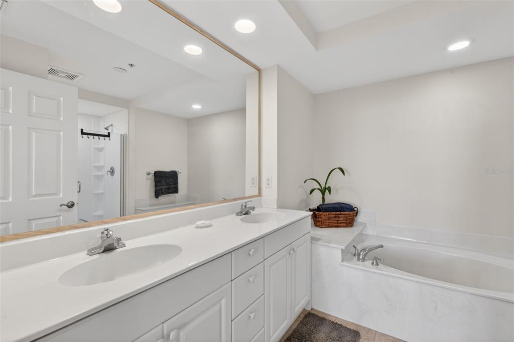 3191 Matecumbe Key Road, Unit 304 Punta Gorda, FL 33955 - Photo 6 of 31 a bathroom with a double vanity sink and mirror with bathtub