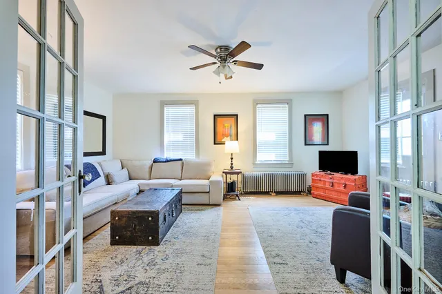 a living room with furniture ceiling fan and a window