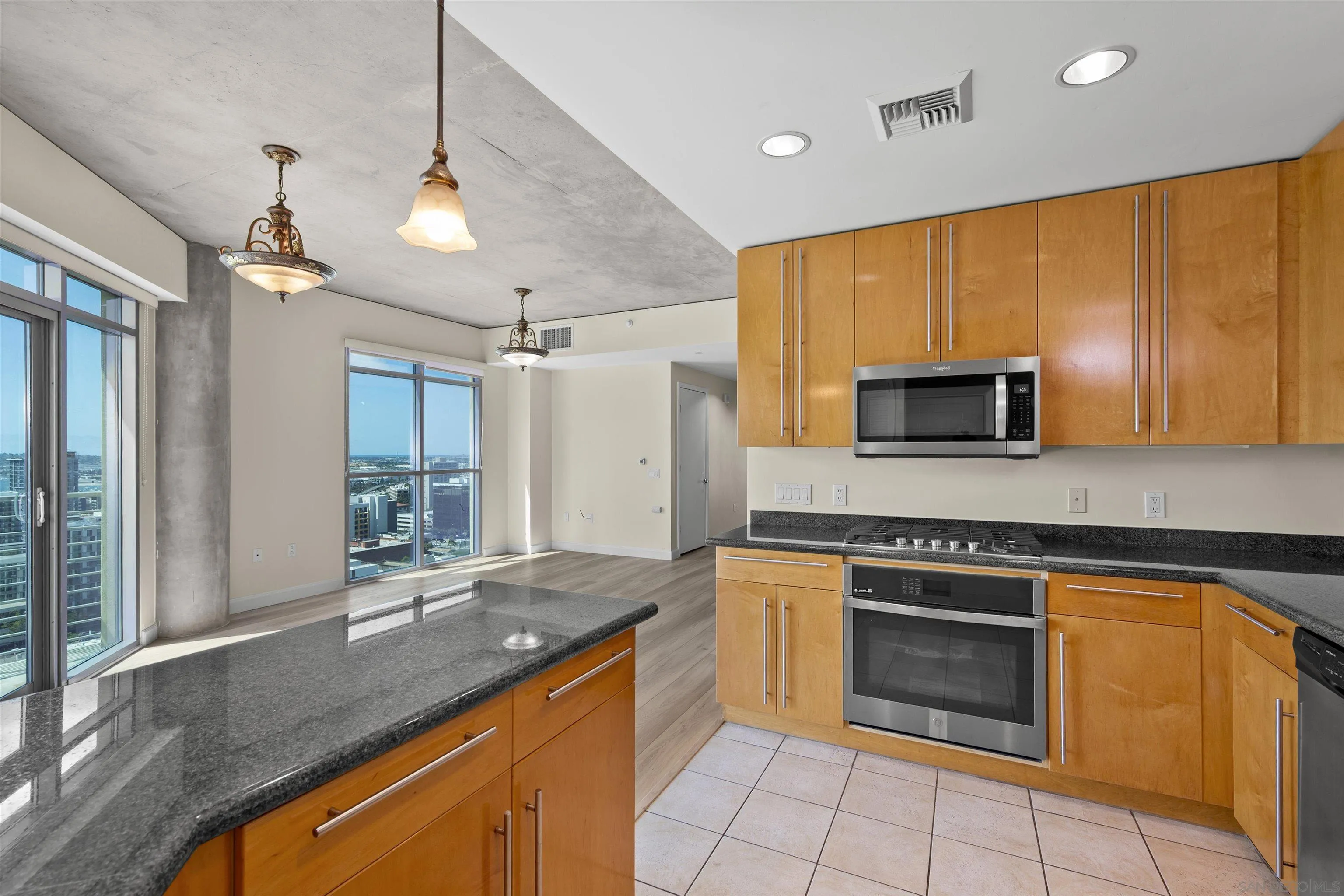 801 Ash Street, Unit 1701 San Diego, CA 92101 - Photo 23 of 44 a kitchen with stainless steel appliances granite countertop a stove a sink and a microwave