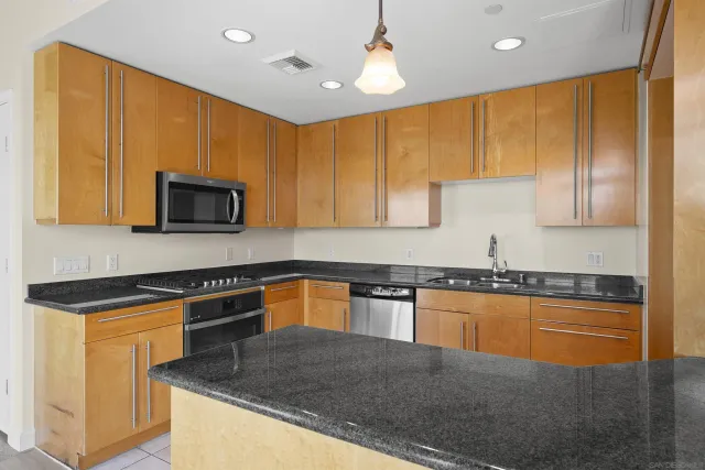 a kitchen with stainless steel appliances granite countertop a stove a sink and a refrigerator